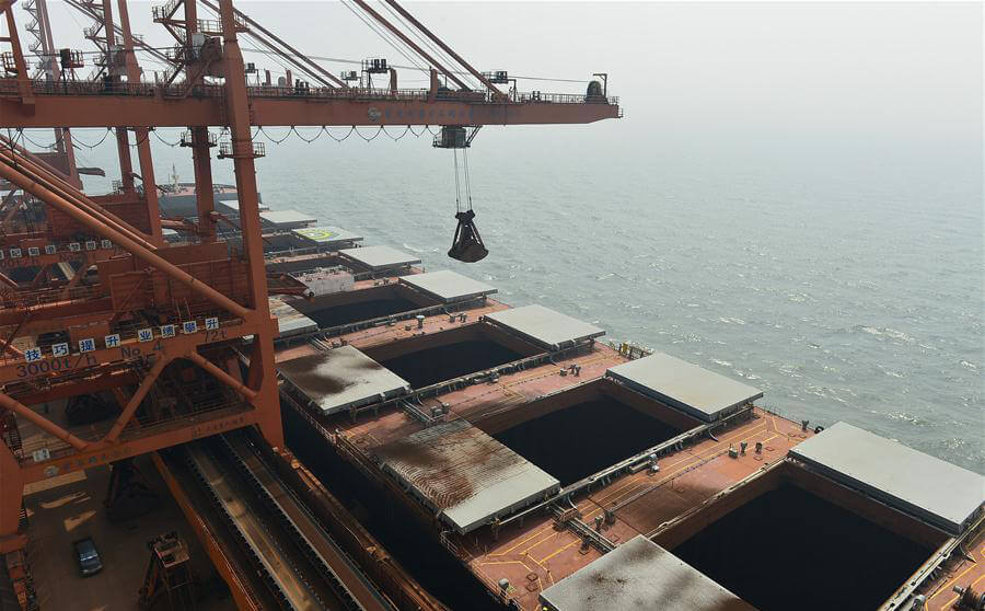 Port cranes are transferring coal from cargo ship